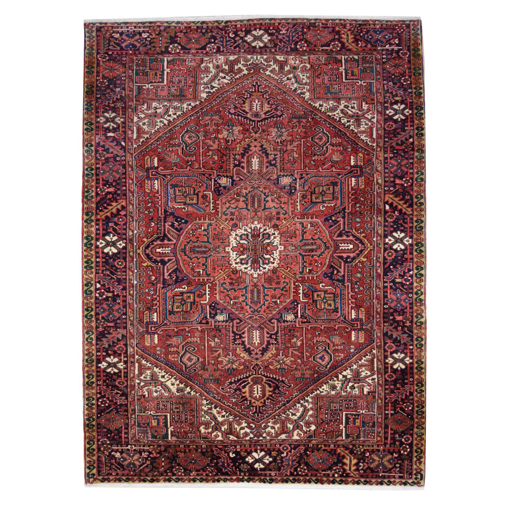 A traditional Persian-style area rug with an intricate geometric and floral pattern, featuring a dominant deep red field with navy, beige, and green accents.