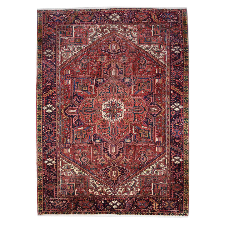 A traditional Persian-style area rug with an intricate geometric and floral pattern, featuring a dominant deep red field with navy, beige, and green accents.